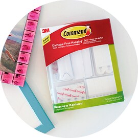 Une Trousse de bandes pour cadres Command(MC) reposant à côté de deux images encadrées.
