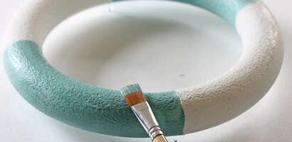 Using a small paint brush, paint two sections in the first color (aqua) and the other two sections in the second color (white)
