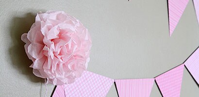 Des Fixations pour bannières Command affichant des pompons en papier sur la bannière.
