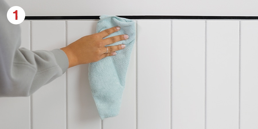 Person cleaning a wall with a cloth.
