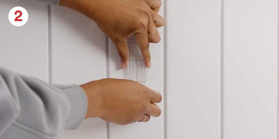 Shows using one hand to hold the mounting base in place.