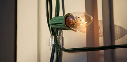 Gros plan d’une seule lumière sur une guirlande fixée à l’aide d’une Pinces pour lumières Command(MC).
