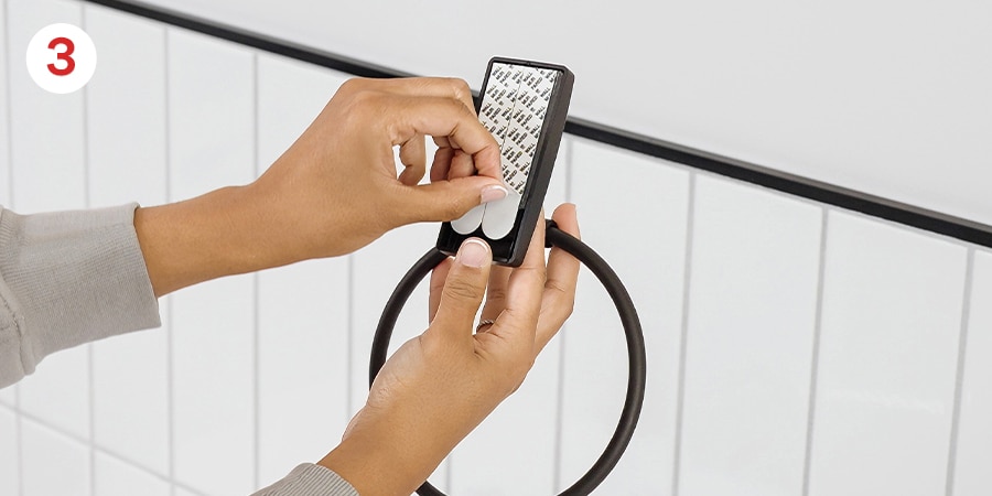 Hands show removing the black liners from the back of the strips.