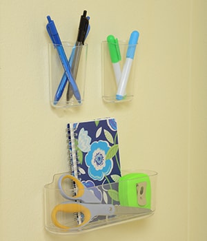 Attach Command™ Clear Small Caddy and Command™  Clear Large Caddy to the wall to hold office supplies

