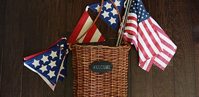 Gather the Command™ products, light, flat wicker basket and the patriotic decorations, including the small American flags on sticks and patriotic pennant flags.
