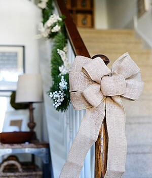 Une boucle dorée accrochée au bas d’une rampe d’escalier.
