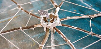 Using the hot glue gun, secure a small loop of ribbon on the center cardboard piece
