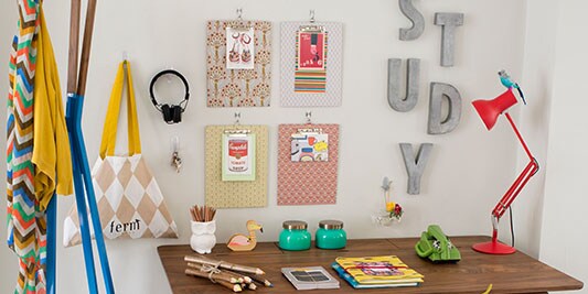organized desk with decorations on the wall above it
