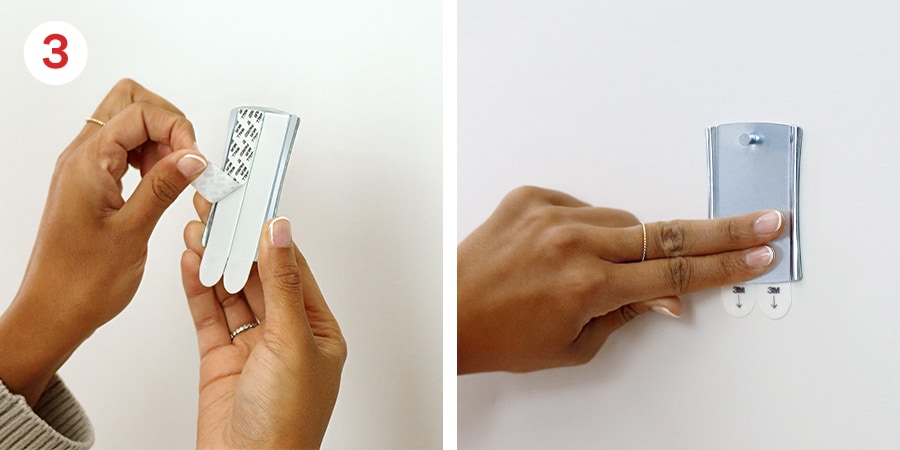 Hands Removing the black liner and presssing the back of the strip firmly against the wall for 30 seconds.