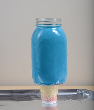 Stand the jar up on a paper or plastic cup to keep the paint from sticking to the table. Let paint dry according to manufacturer's instructions.
