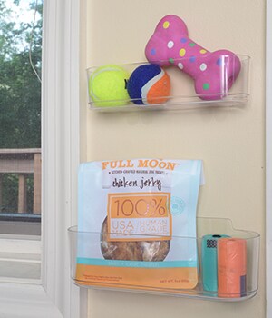 Hang CommandTM Clear Medium and Large Caddies on the wall to hold bags for cleaning up after your dog, treats and small toys.
