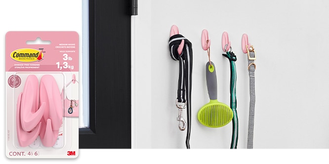 Command™ Designer Hooks on a wall holding pet leashes, brushes and collars.
