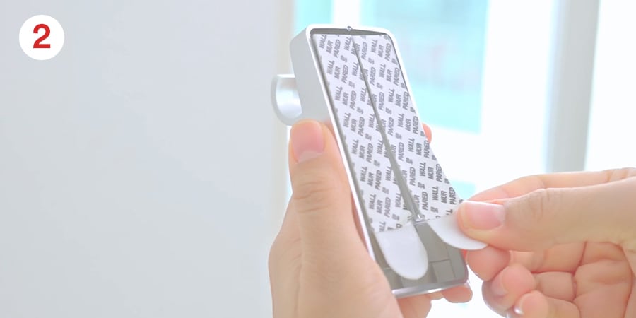 Hands show pressing the strips onto the mounting base.