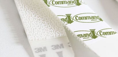 The front and back sides of a Command™ Picture Hanging Strip.
