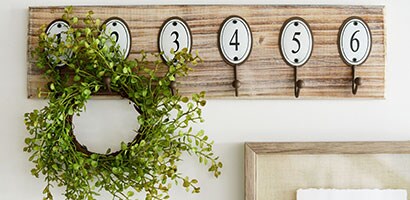Decorative plaque of numbered hooks applied to a white all.
