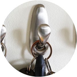 Silver metal Command™ Brand wall hook with a set of keys hanging from it.
