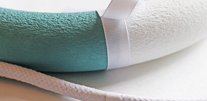 Use a hot glue gun to secure one end of the ribbon to the back of the wreath

