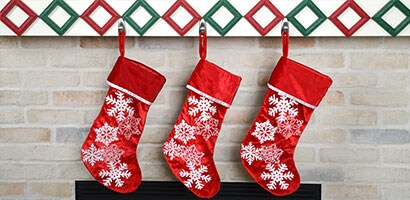 Trois bas de Noël rouges accrochés à l’aide de Crochets métalliques Command(MC).
