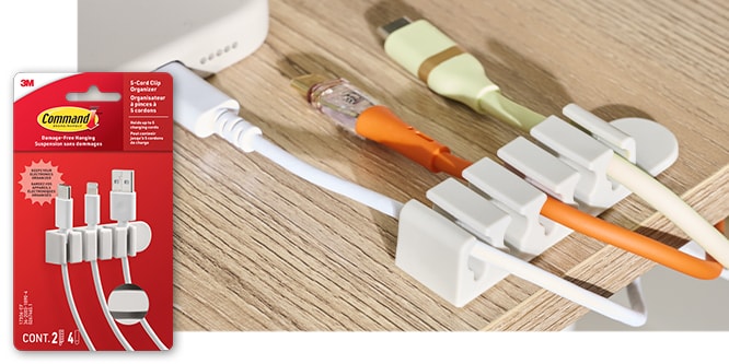 Command™ 5-cord clip organizer holding 3 cords on a desk. Product in package in lower left corner.
