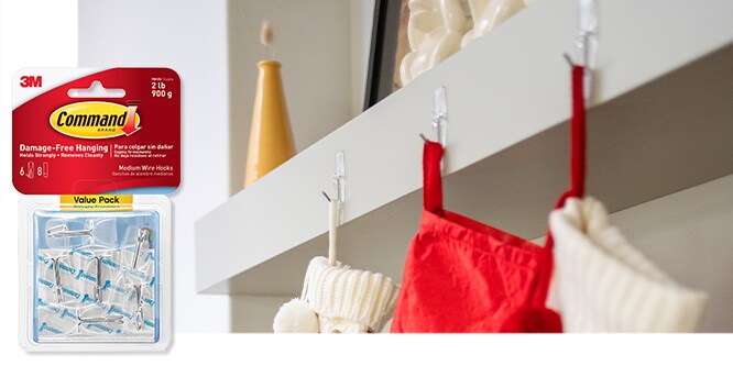 Command™ Small Wire Hooks shown in use, holding up stockings on a fireplace.
