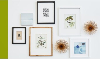 Variety of picture frames, in various sizes and weights, hung on a wall using various Command™ picture hanging options.
