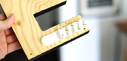 To hang the letters to spell “EAT” on the door, first remove the Command™ Picture Hanging Strips from the package and separate each strip
