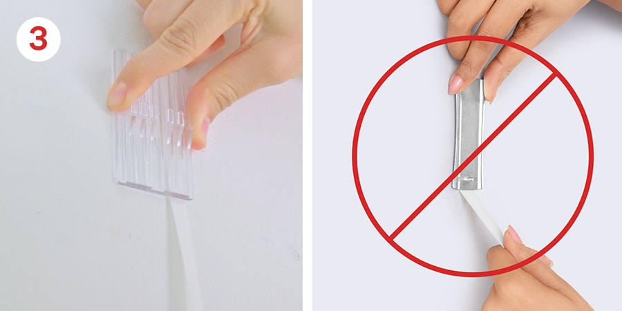 Hands pull the strips down against the wall to remove.