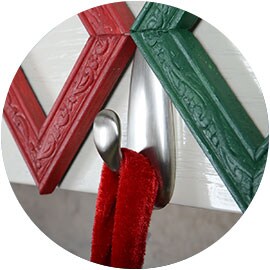 Gros plan d’un Crochet métallique Command(MC) fixé à un manteau de cheminée blanc.

