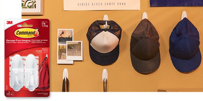 Command™ Medium Hook, behind the product in package, the hook is used to hold a variety of hats and bags on the wall.
