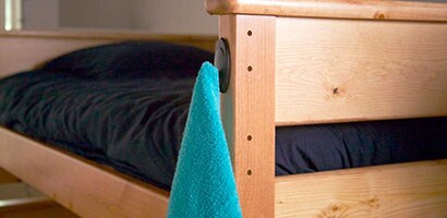 A blue towel hanging on a black Command Double Hook.
