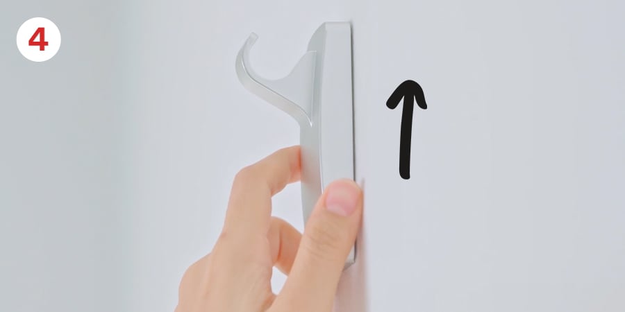 Step 4 - Hand and an arrow show removing the hook from the baseplate by sliding up and off.