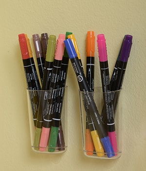 Use Command™ Clear Small Caddies to hold pens and markers.

