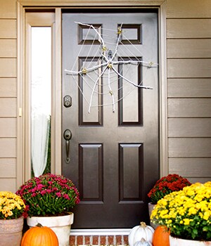 Hang the spider web wreath on the front door by sliding the ribbon loop over the Command™ Outdoor Medium Slate Terrace Hook
