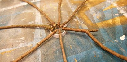 Use the center cardboard piece of an old spool of ribbon as the center of the spider web wreath
