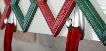Gros plan de deux Crochets métalliques Command(MC) fixés à un manteau de cheminée blanc.
