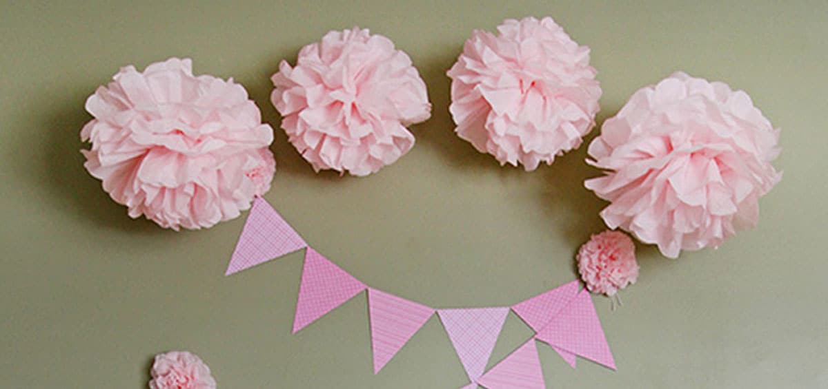 Des bannières et des fleurs en papier mâché, fixées à un mur par des Fixations pour bannières Command.