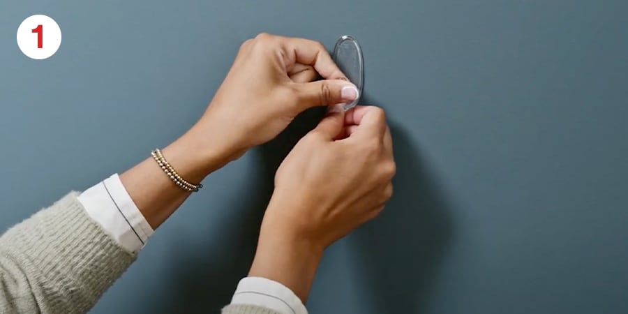 Hands hold hooks gently in place.
