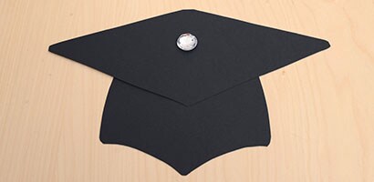 cutouts assembled with a brad attached to the mortarboard.
