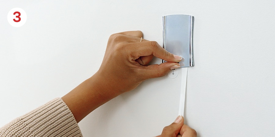 A hang stretching the strip down against the wall