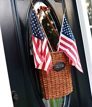 Place the small American flags in the wicker basket so the flags are visible from the top of the basket
